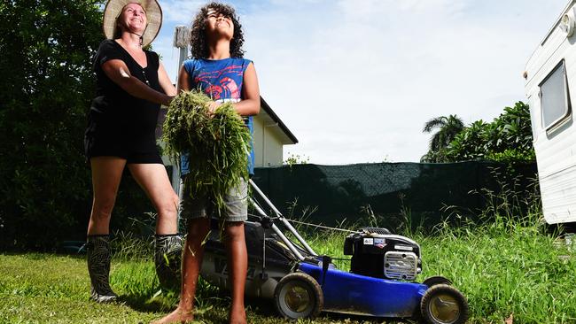 Georgina Wilson and Gigi Burarrawanga-Wilson 9 offer up a sacrifice of fresh grass clippings to the gods to keep the monsoon at bay. Picture: Helen Orr