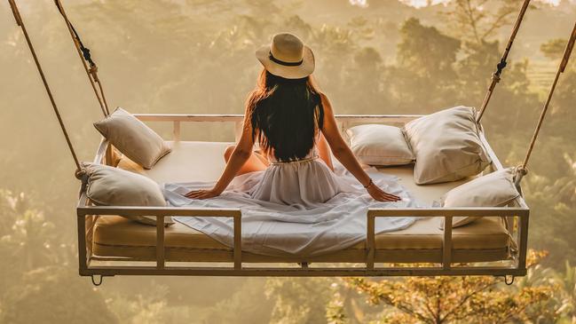 A young woman sits on a swing in Bali, Indonesia. Picture: iStock