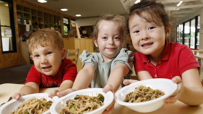 Charlie, 3, Isabella, 4, and Skye, 4, enjoy their chef-prepared meal at C&amp;K Kedron childcare centre. Picture: Josh Woning