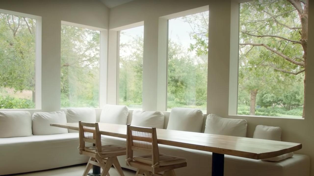 A breakfast nook looks out onto a tranquil green garden.