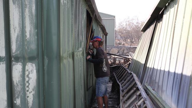 Ross Stanbridge looking into a shed that had $200,000 worth of vintage cars destroyed. Picture: David Swift.