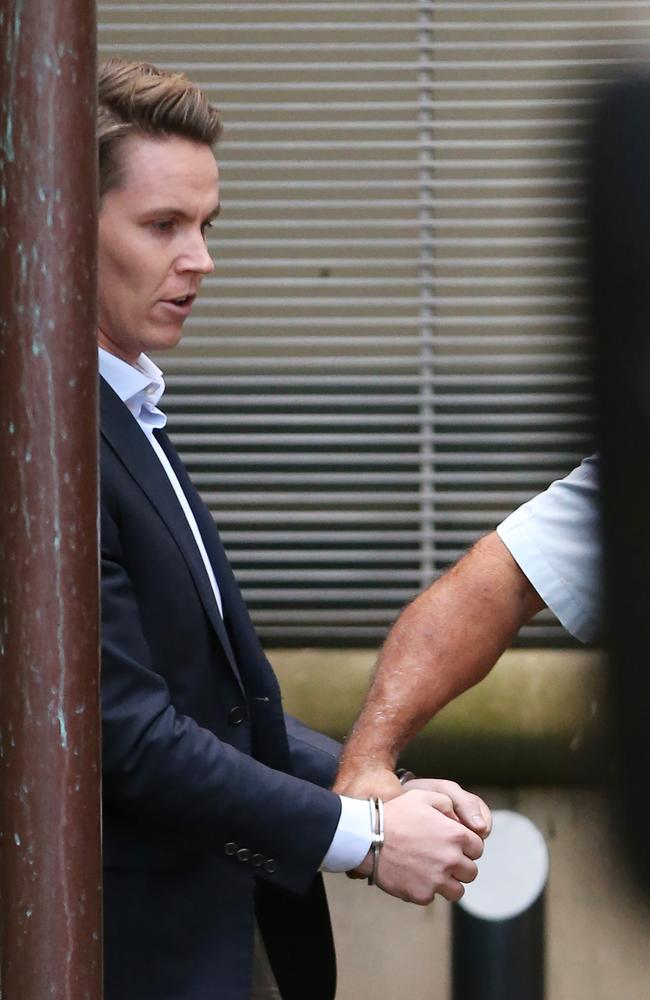 Curtis is led, handcuffed, to a waiting prison transport van after being sentenced for insider trading. Picture Craig Greenhill