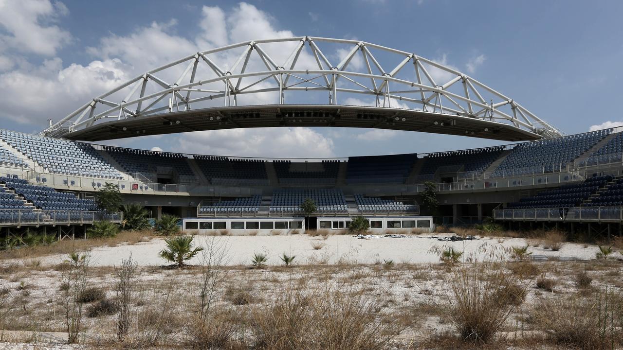 In this Friday, Aug. 8, 2014 photo, the abandoned beach volleyball Olympic venue is seen in Neo Faliro, southern Athens. As Greece groans under a cruel depression, forecast to end this year, the 10-year anniversary once again raises the question of whether the Athens Games were too costly an undertaking for a weak economy. (AP Photo/Thanassis Stavrakis)