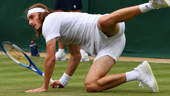 Greek star Stefanos Tsitsipas goes down as he returns during his Wimbledon first round loss to Italy’s Thomas Fabbiano. Picture: AFP