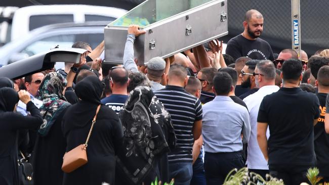 Mourners lift an empty coffin above their heads during the burial of Mahmoud 'Mick' Hawi.