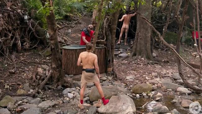 Harry Garside showers as his campmates wash up.