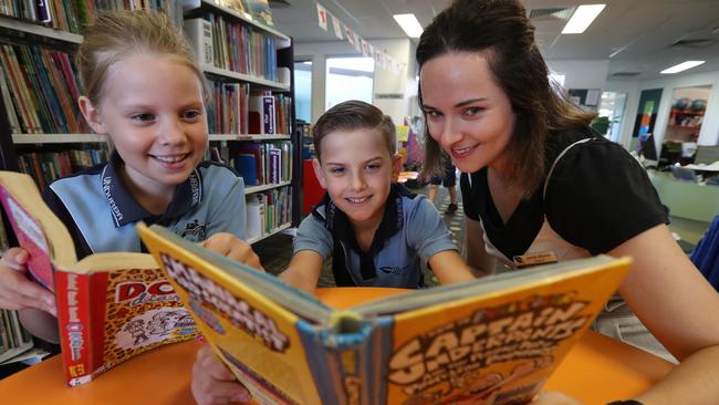 Teacher Jamie Morris in the library with students Brandon Smith and Lilly Myers, both 9, at Undurba State School. Picture: Lyndon Mechielsen