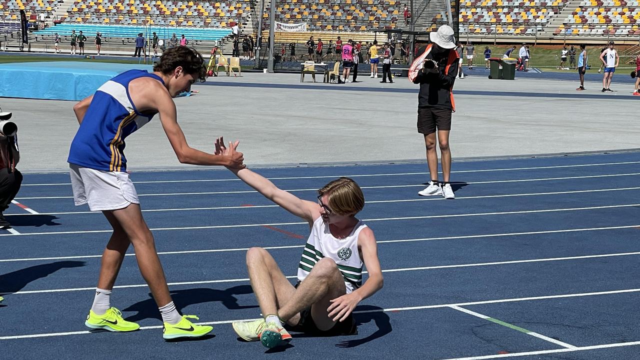 Seth Mahony is helped to his feet by Charlie Moore of Churchie.