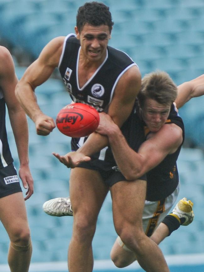 Lincoln McCarthy tackles Port's Aseri Raikiwasa while playing for Glenelg in the Macca’s Cup Final in 2011.