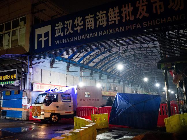 Members of staff of the Wuhan Hygiene Emergency Response Team drive their vehicle as they leave the closed Huanan Seafood Wholesale Market in the city of Wuhan. Picture: AFP