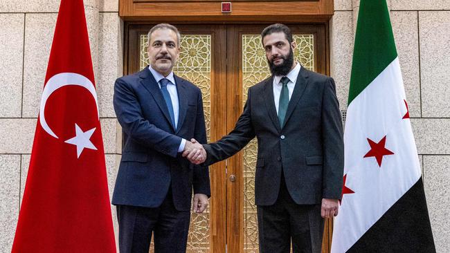 Turkey's Foreign Minister Hakan Fidan (L) being received by Hayat Tahrir al-Sham (HTS) leader Ahmed al-Sharaa in Damascus. Picture: AFP.