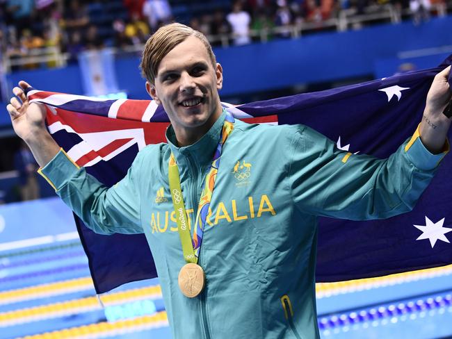 Australia's Kyle Chalmers waves his national flag during the medal ceremony of the Men's 100m Freestyle Final during the swimming event at the Rio 2016 Olympic Games at the Olympic Aquatics Stadium in Rio de Janeiro on August 10, 2016.   / AFP PHOTO / CHRISTOPHE SIMON