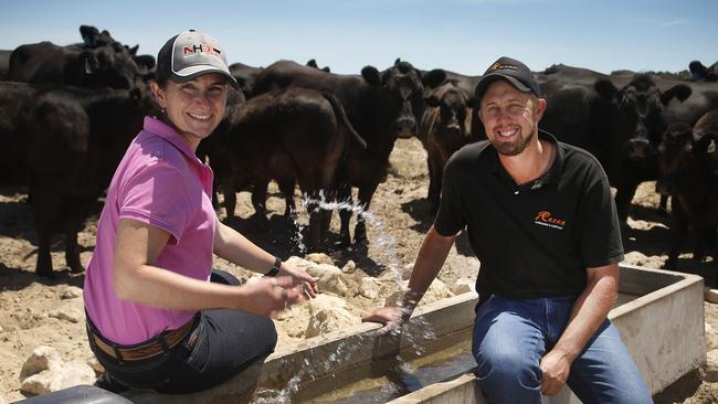Penny and Jason Schulz at a water trough on their property. Picture Dean Martin