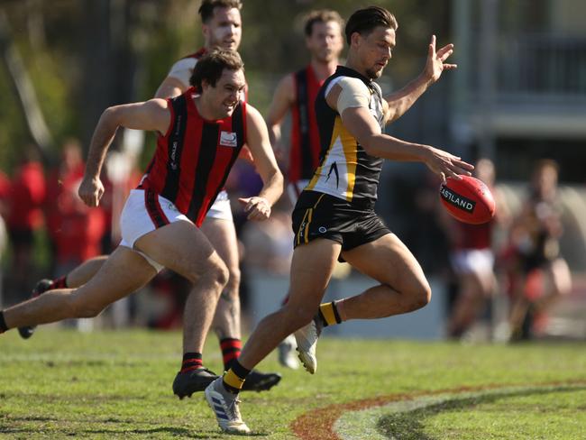 Cameron Manuel sends the ball inside 50. Picture: Stuart Milligan