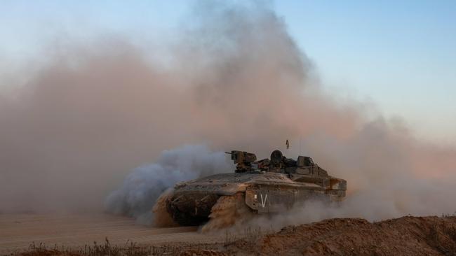 An Israeli military armoured vehicle rolls in an area bordering the Gaza Strip, amid the ongoing conflict between Israel and the Palestinian Hamas militant group. Picture: AFP