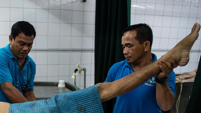 Embalmers Alejandro Ormeneta (right) and Orlando Cadiente embalming a body inside the morgue of Veronica Memorial Chapel in Manila. Picture: AFP / Noel Celis.