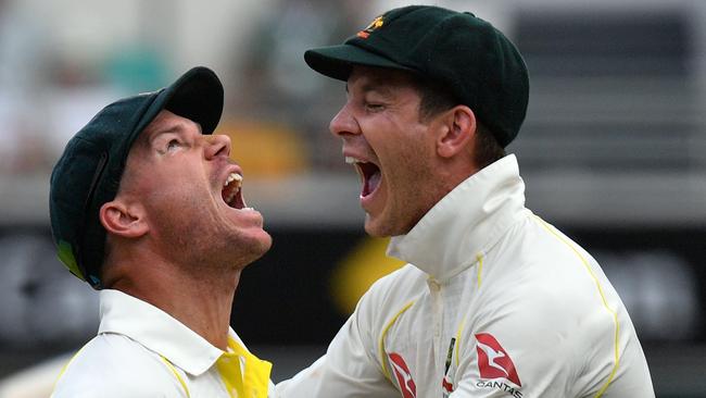 David Warner (left) and Tim Paine celebrate after Warner caught England’s Jake Ball in the first Ashes Test at the Gabba in 2017. Picture: AFP  