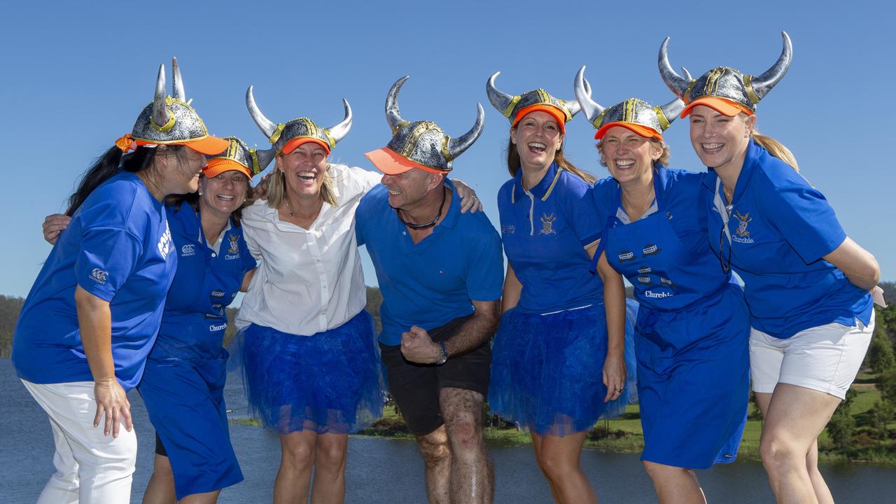 Churchie parents (from left) Susan Ardrey, Annabel Earnshaw, Alicia Hanham, Steve Jenkins, Andrea Skerl, Leanne Johnston and Sally Taylor get behind their school at the GPS Head of the River, Lake Wyaralong. Picture: Sarah Marshall/AAP