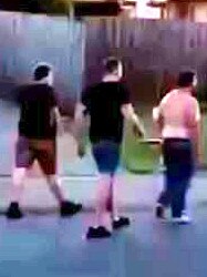 Three men are seen walking through the residential street as a car approaches.