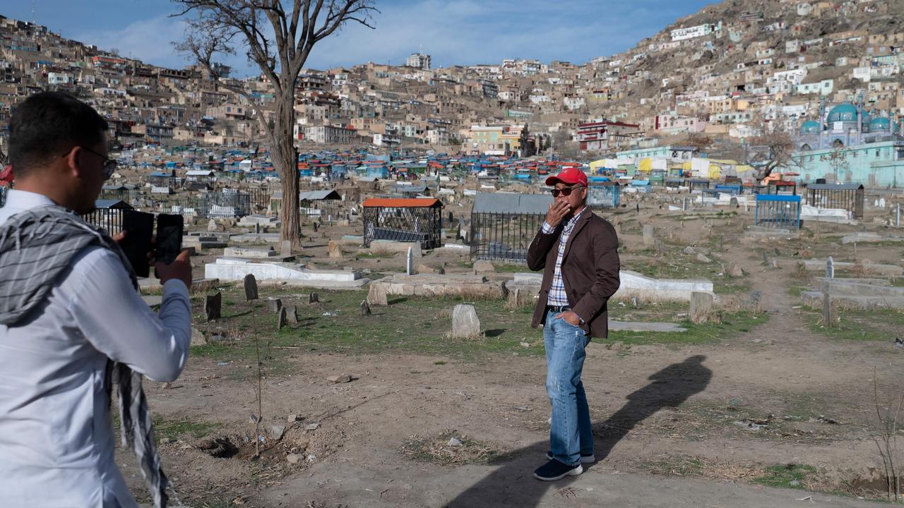 An Afghan guide takes a picture of a tourist during a visit at the Karte Sakhi cemetery in Kabul in March. Picture: Wakil Kohsar / AFP