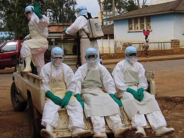 APRIL 9, 2005: Five health workers, dressed in head-to-toe "Ebola suits" leave in a pick-up truck in Uige, 09/04/05, to collect a man dying from haemorrhagic fever. Uige, a town devastated by years of civil war is the epicentre of an outbreak of the killer Marburg virus which has claimed 180 lives so far.Angola / Medical