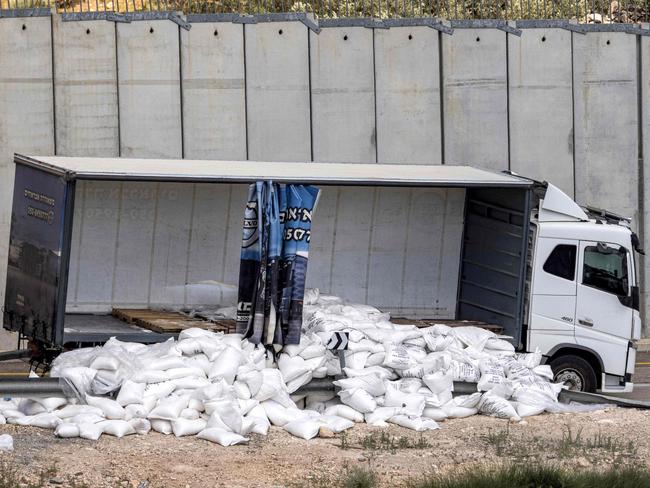 A damaged trailer truck that was carrying humanitarian aid supplies parked along the Israeli side of Israel's controversial separation barrier with the West Bank. Picture: AFP