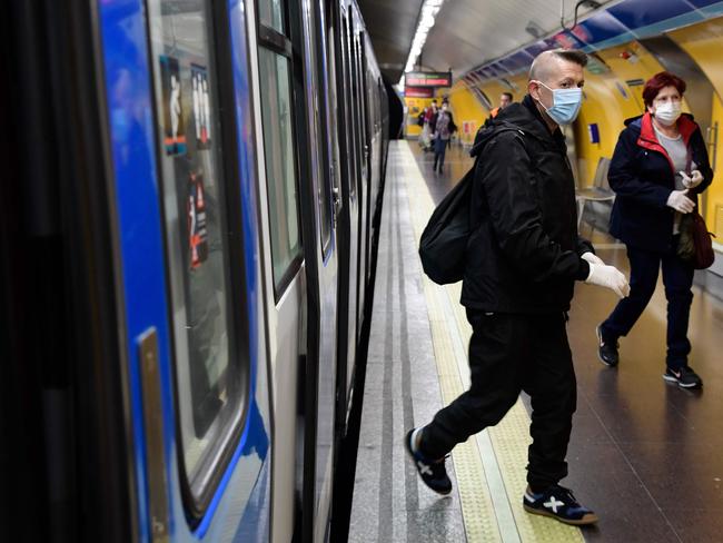 Commuters wearing face masks arrive at the Atocha Station in Madrid as some companies resume operations. Picture: AFP