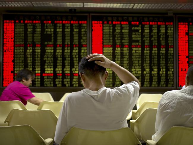 Investors monitor displays of stock information at a brokerage house in Beijing, Wednesday, July 15, 2015. Shanghai stocks lost ground on Wednesday despite China's better-than-expected economic growth in the second quarter, with investors still wary after a big slide in Chinese markets. (AP Photo/Mark Schiefelbein)