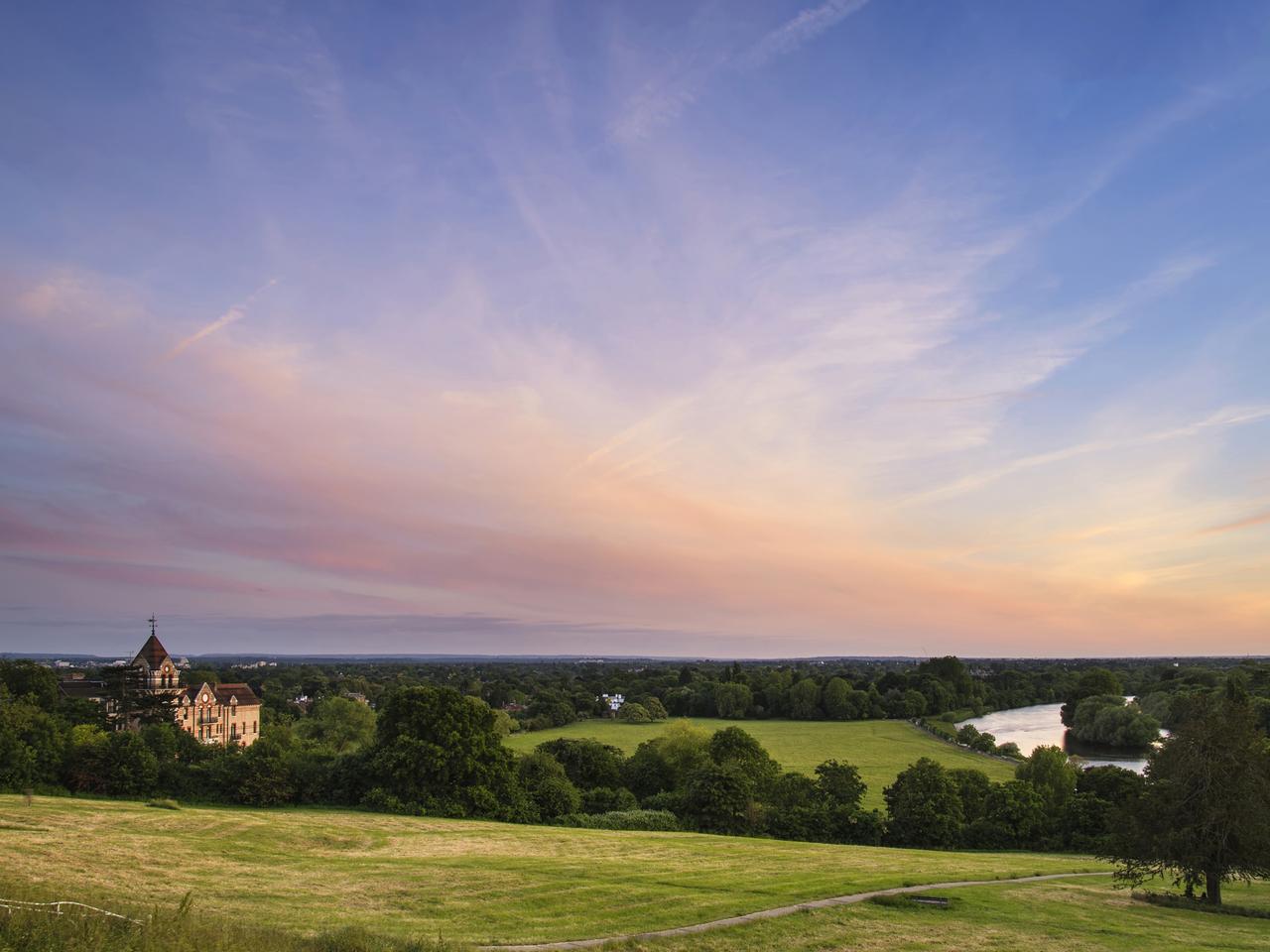 Colorful sunset landscape over fields and River Thames on Richmond Hill in London.