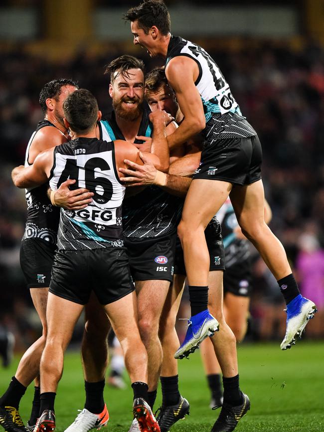 Port Adelaide’s Charlie Dixon is swamped by his teammates after kicking his 200th AFL goal in the Power’s win over the Geelong Cats at Adelaide Oval. PHOTO: Daniel Kalisz/Getty Images