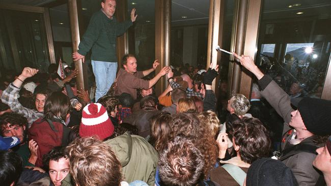 A tyre wrench is handed to other protesters as they attempt to force open another door at the front of Parliament House during the August 1996 riot.