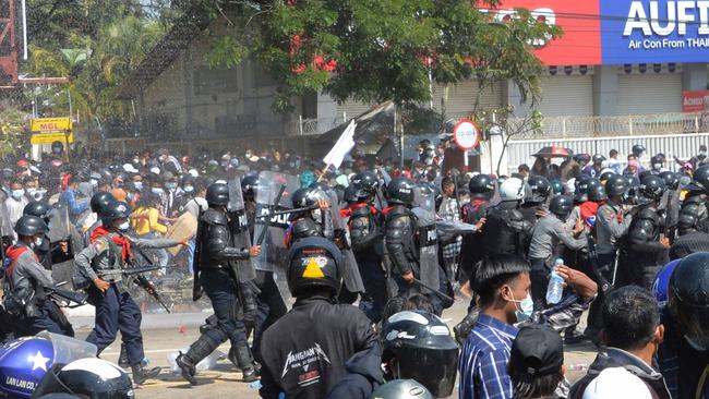 Myanmar police armed with automatic rifles move in on protesters. Picture: AFP