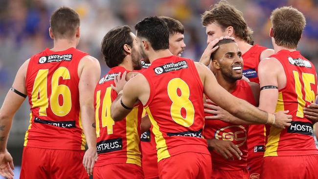 Miller is surrounded by Gold Coast teammates during their Round 1 win over Eagles.