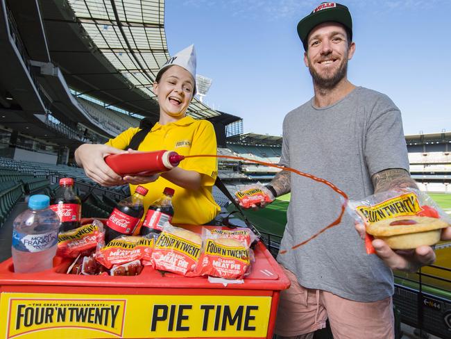 Pie vendor Bridget Schwerdt, 19, and ex Collingwood player Dane Swan. FourÕN Twenty's 60th anniversary at the MCG, To celebrate the anniversary the completely new FourÕN and Twenty Craft Beer Pie is launching in stadium for spectators to be the first in Australia to take a bite of the pies. Picture: Jason Edwards