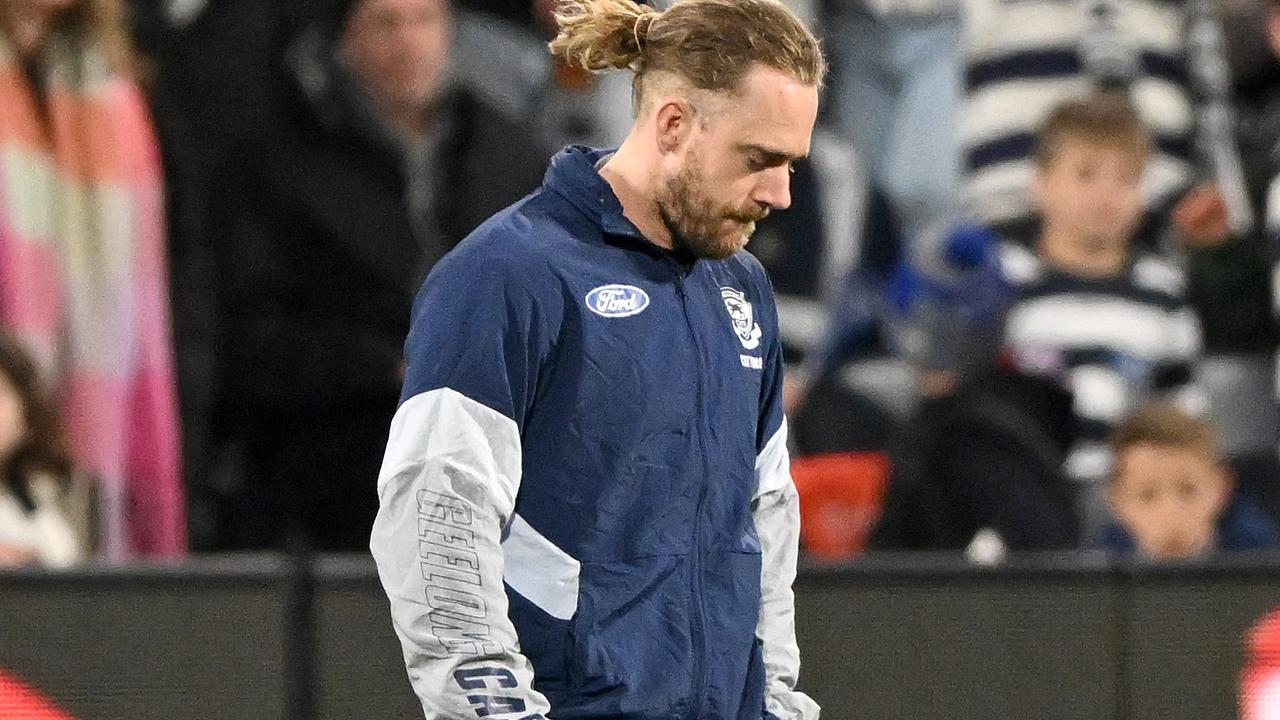 Cameron Guthrie walks to the huddle in a tracksuit during the match between the Cats and the Eagles at GMHBA Stadium.