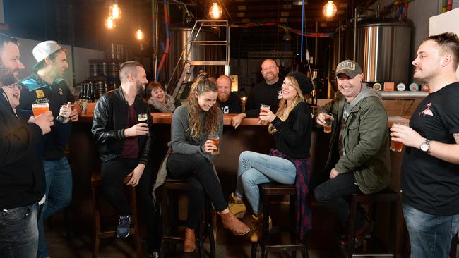 Big Shed owners Craig Basford and Jason Harris (behind the bar) with customers at their Royal Park brewery. Picture Campbell Brodie