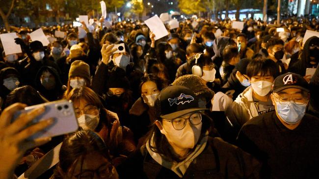 Protesters march along a street during a rally for the victims of a deadly fire as well as a protest against China's harsh Covid-19 restrictions in Beijing on Monday night. Picture: AFP