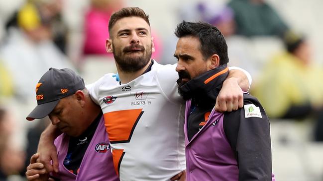 Stephen Coniglio is assisted off the field after hurting his knee against the Tigers. Picture: AAP