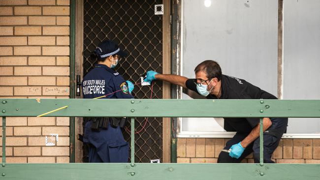 Forensics officers looking at bullet holes at the house in Dickens Road in Ambarvale, where 65-year-old grandmother Kim Duncan was killed. Picture: Julian Andrews.