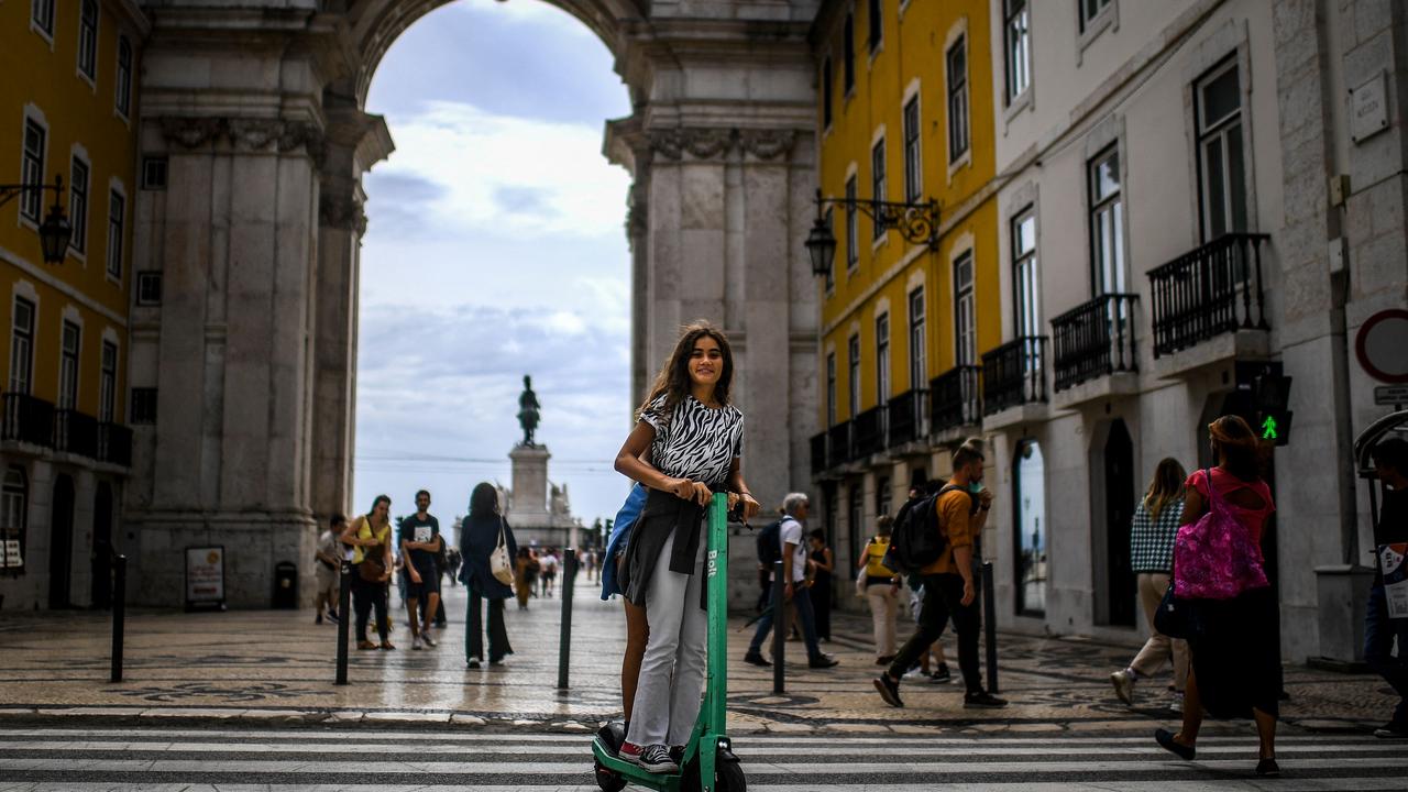 Two girls drive a scooter in front of Rua Augusta arch in downtown Lisbon on the same day Portugal ended the Covid-19 measure of mandatory use of mask in the streets. Picture: Patricia De Melo Moreira / AFP