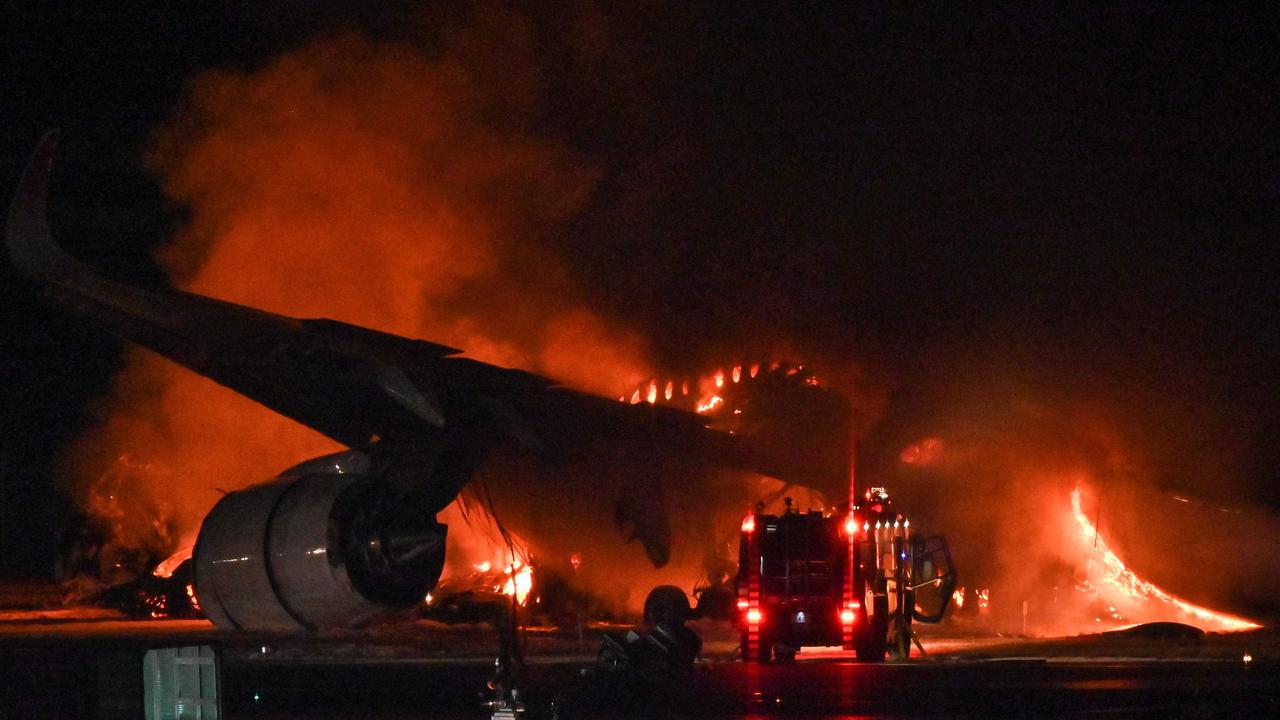 A Japan Airlines (JAL) passenger plane is seen on fire on the tarmac at Tokyo International Airport. (Photo by Richard A. Brooks / AFP)