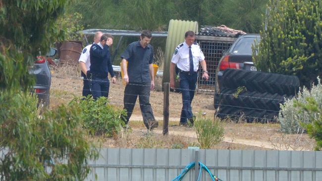 Gene Bristow, in blue short sleeved shirt, with sheriff’s officers on his property in Meningie. Picture: AAP / Brenton Edwards