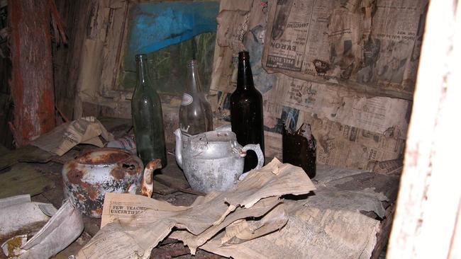 Some of the memorabilia found at the hut — an old table, teapots, bottles and a rusted pitchfork. The walls were lined with 1954 editions of <i>The Mercury</i>. 