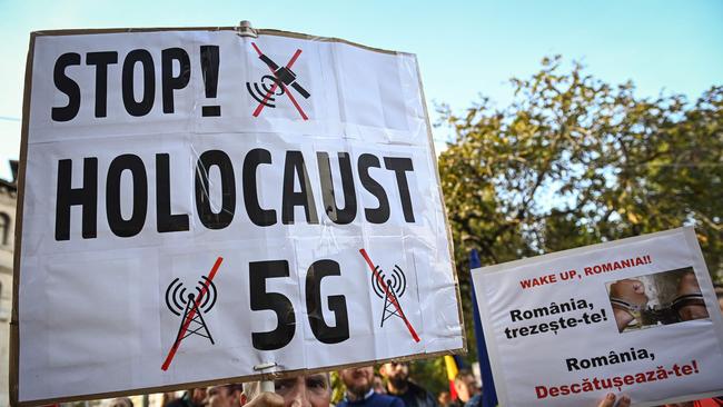 A man holds a placard reading "Stop 5G Holocaust!" during anti-coronavirus regulations protests in Bucharest. Picture: AFP