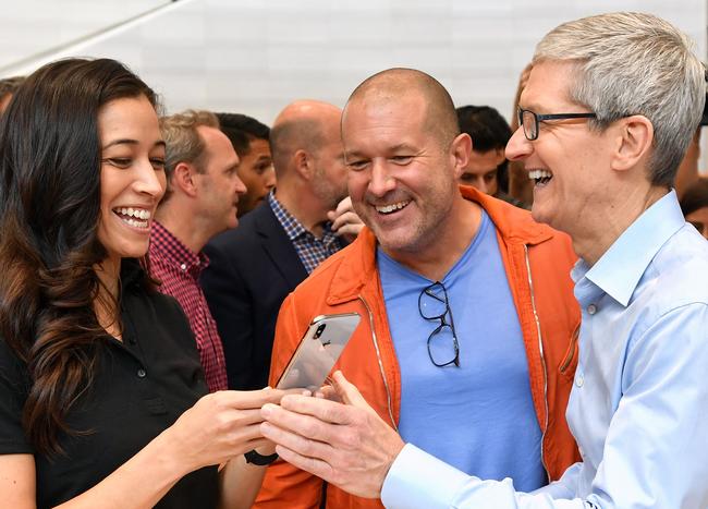 Apple CEO Tim Cook (R) tests out a new iPhone X during a media event at Apple's new headquarters in Cupertino, California on September 12, 2017.  / AFP PHOTO / Josh Edelson