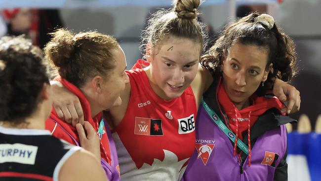 An injured Montana Ham is helped off the ground after what appeared to be a serious leg injury. Picture: Mark Evans/AFL Photos/via Getty Images