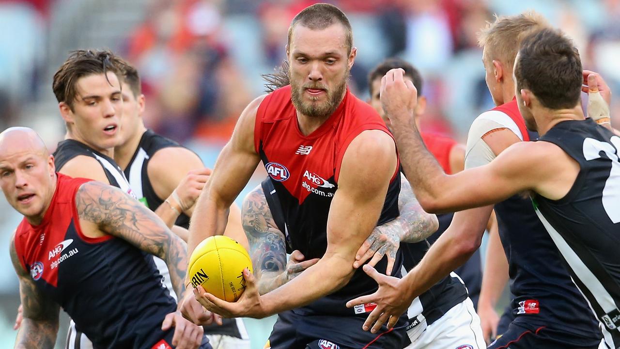 MELBOURNE, AUSTRALIA - JUNE 08: Max Gawn of the Demons handballs whilst being tackled by Dane Swan of the Magpies during the round 10 AFL match between the Melbourne Demons and the Collingwood Magpies at Melbourne Cricket Ground on June 8, 2015 in Melbourne, Australia. (Photo by Quinn Rooney/Getty Images)