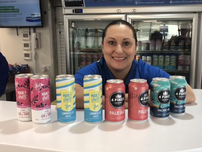 Manly Fast Ferry Deckhand Olivia Lizzio with a selection of the new 4 Pines and Manly Spirits products to be served on the vessels. Picture: Jim O’Rourke