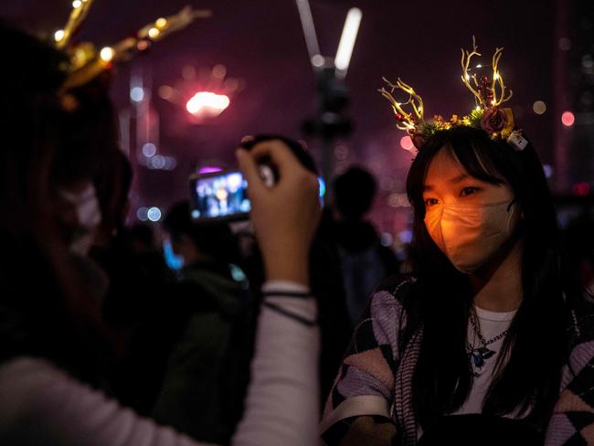 Revellers take photos during a fireworks and laser show as they celebrate the New Year next to Victoria Harbour in Hong Kong. Picture: AFP