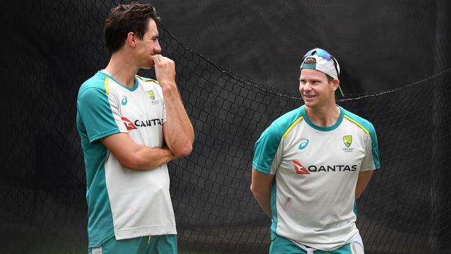 Australian cricket captain Pat Cummins speaks with teammate Steve Smith. Photo by William WEST / AFP